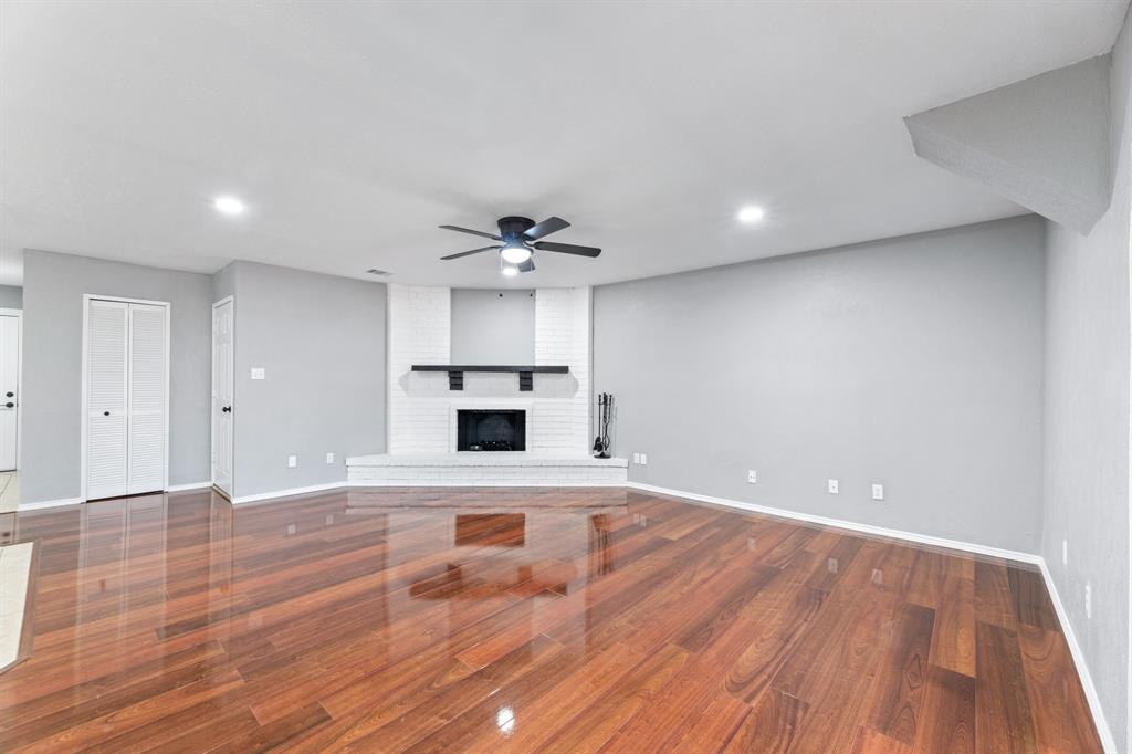 100 West Way Drive Allen, TX 75002 - Photo 8 of 31 Unfurnished living room with a fireplace, ceiling fan, wood finished floors, and recessed lighting