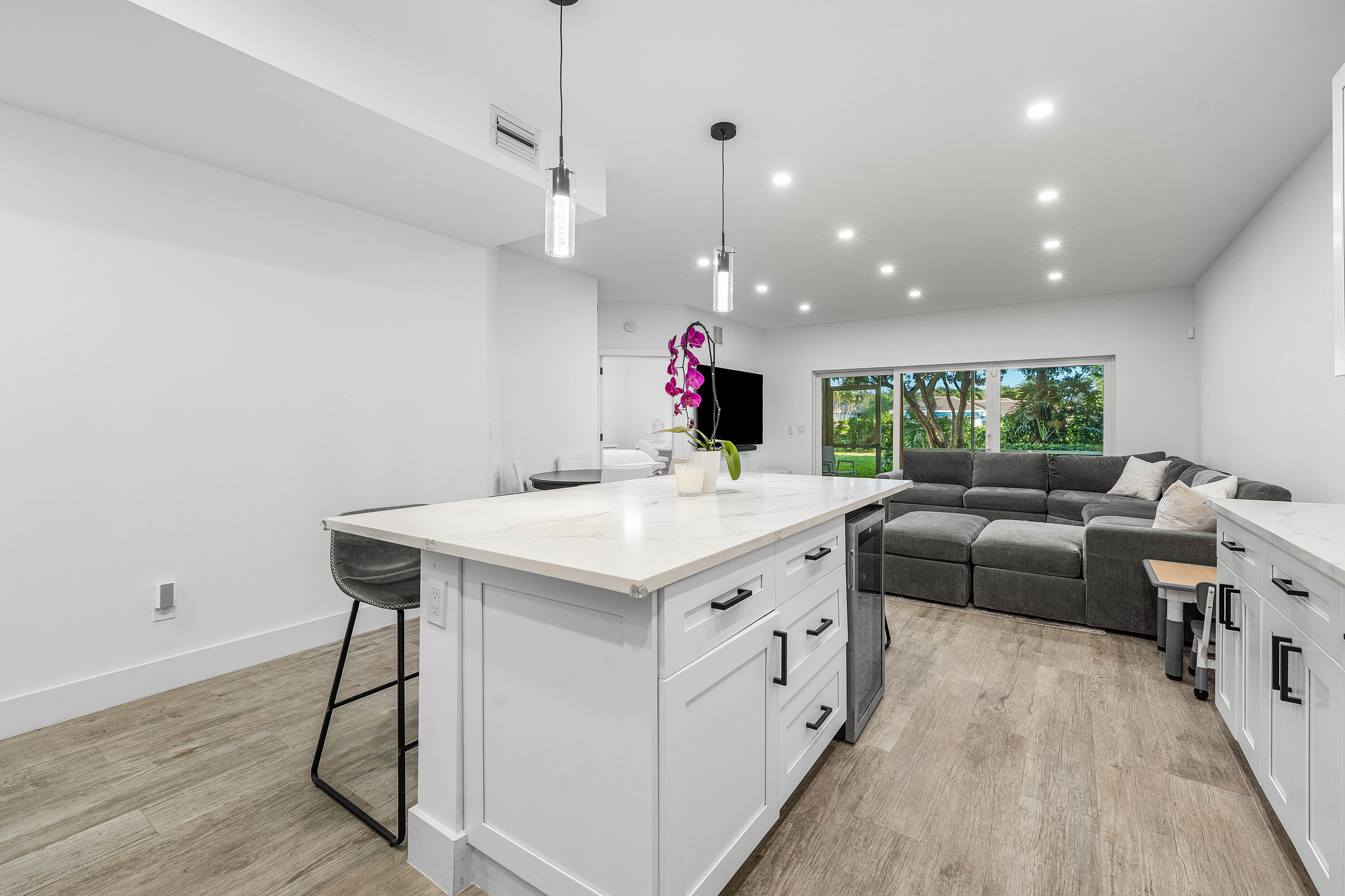 6229 Graycliff Drive, Unit A Boca Raton, FL 33496 - Photo 7 of 33 a kitchen with kitchen island a sink and a living room view