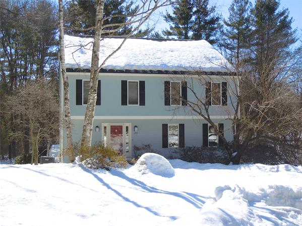 a front view of a house with a yard covered in snow