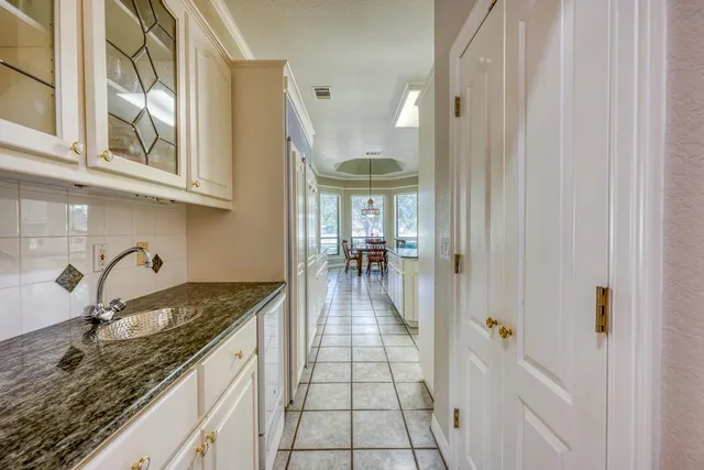 a hallway with a sink and cabinets