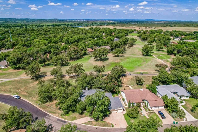 an aerial view of residential houses with outdoor space and a lake view