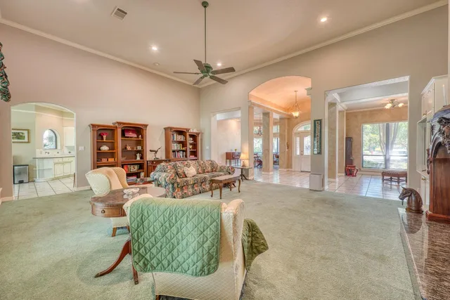 a living room with furniture a chandelier and a dining table