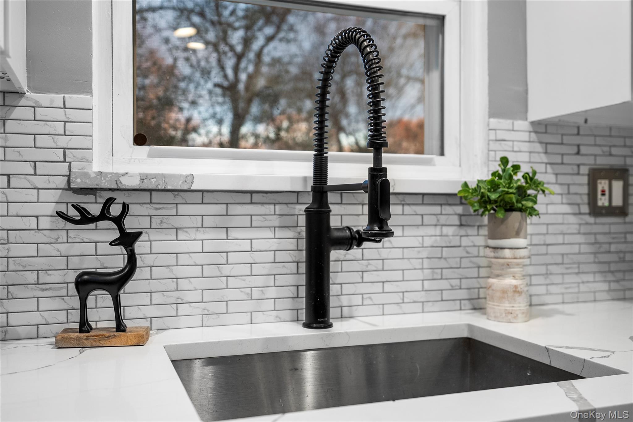 19 Corvette Road Selden, NY 11784 - Photo 11 of 28 Kitchen view of tasteful backsplash, light stone counters, and white cabinets