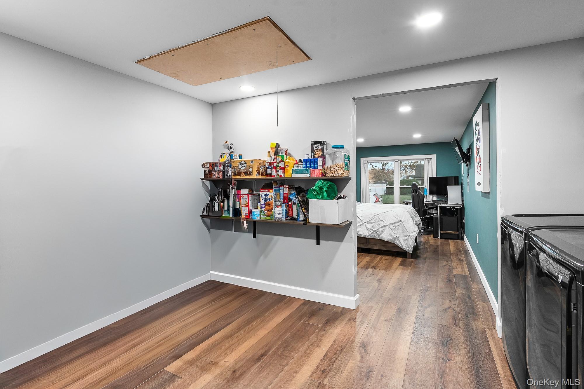 19 Corvette Road Selden, NY 11784 - Photo 14 of 28 Bedroom featuring attic access, dark wood-type flooring, recessed lighting, washing machine and clothes dryer, and wine cooler