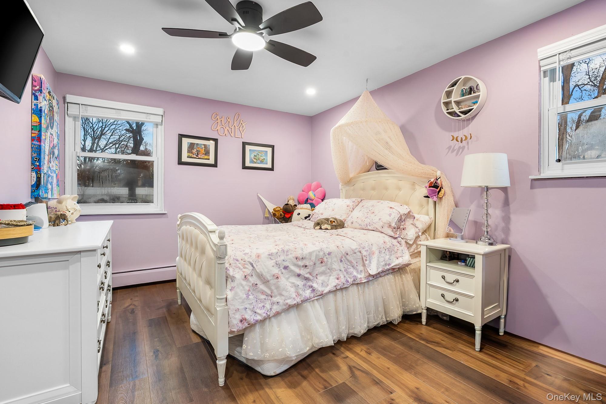 19 Corvette Road Selden, NY 11784 - Photo 18 of 28 Bedroom with baseboard heating, ceiling fan, dark wood-style floors, and recessed lighting