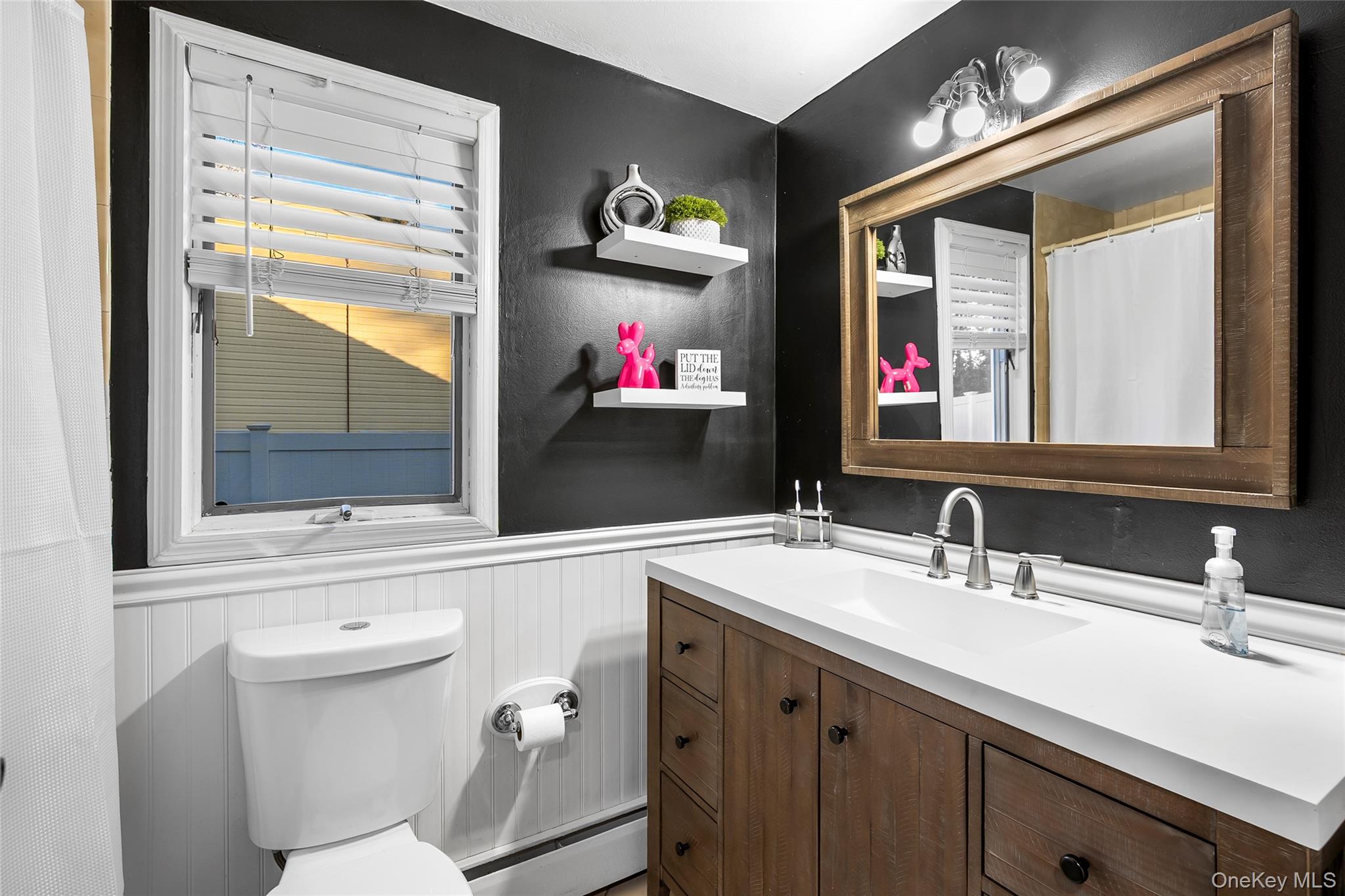 19 Corvette Road Selden, NY 11784 - Photo 20 of 28 Bathroom with curtained shower, vanity, baseboard heating, and wainscoting