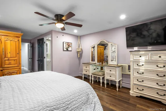 a bedroom with a bed a dresser and flat screen tv
