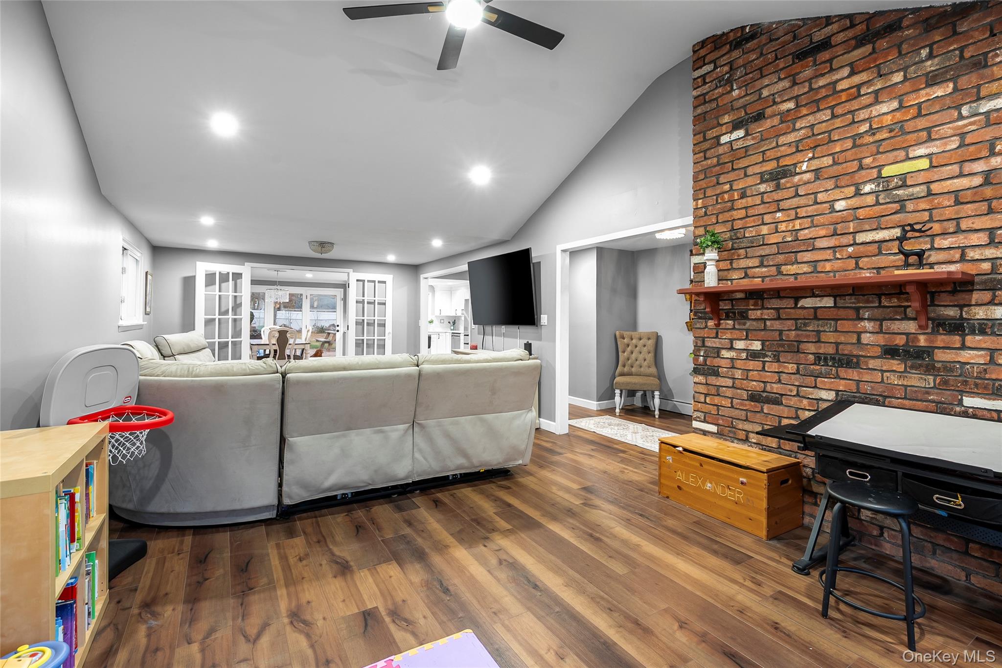 19 Corvette Road Selden, NY 11784 - Photo 5 of 28 Living area with vaulted ceiling, dark wood-style floors, recessed lighting, and a ceiling fan