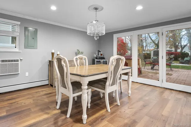 a dining room with wooden floor a chandelier a glass table and chairs