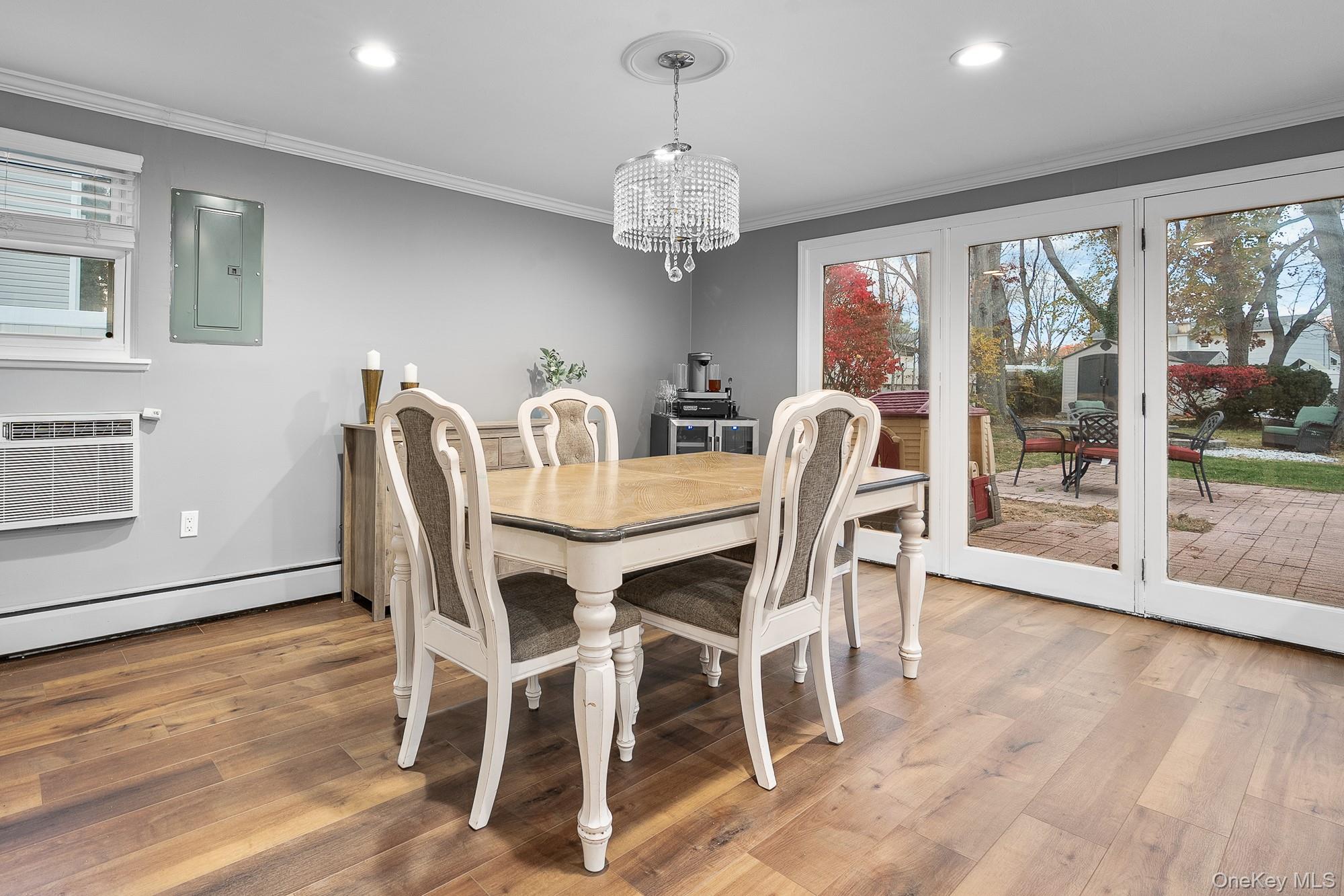 19 Corvette Road Selden, NY 11784 - Photo 9 of 28 Dining space featuring light wood-type flooring, electric panel, a chandelier, crown molding, and recessed lighting