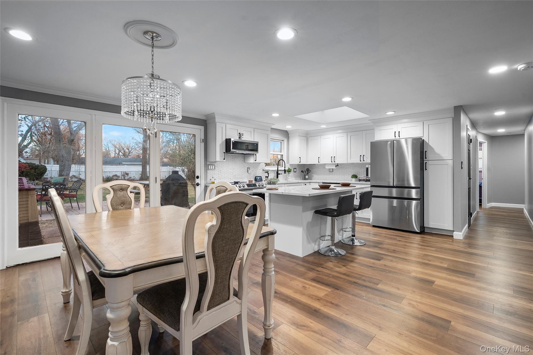 19 Corvette Road Selden, NY 11784 - Photo 10 of 28 Dining room featuring dark wood-type flooring, a chandelier, recessed lighting, and a skylight