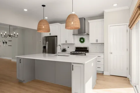 a kitchen with stainless steel appliances a sink a stove a refrigerator and cabinets