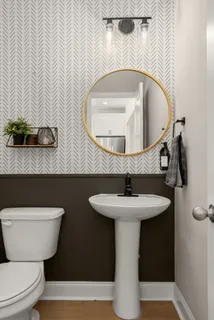 a bathroom with a toilet sink and mirror