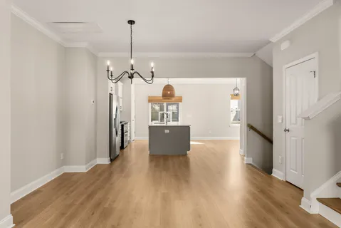 a view of a room with wooden floor a ceiling fan and window