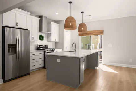 a kitchen with kitchen island white cabinets and refrigerator