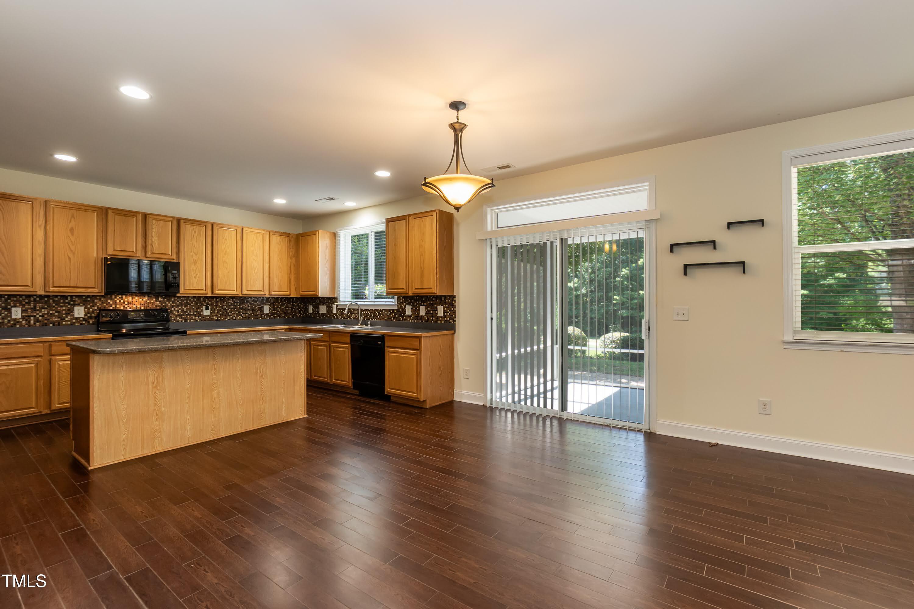418 Byrams Ford Drive Cary, NC 27513 - Photo 13 of 53 a large kitchen with granite countertop a stove and a wooden floors