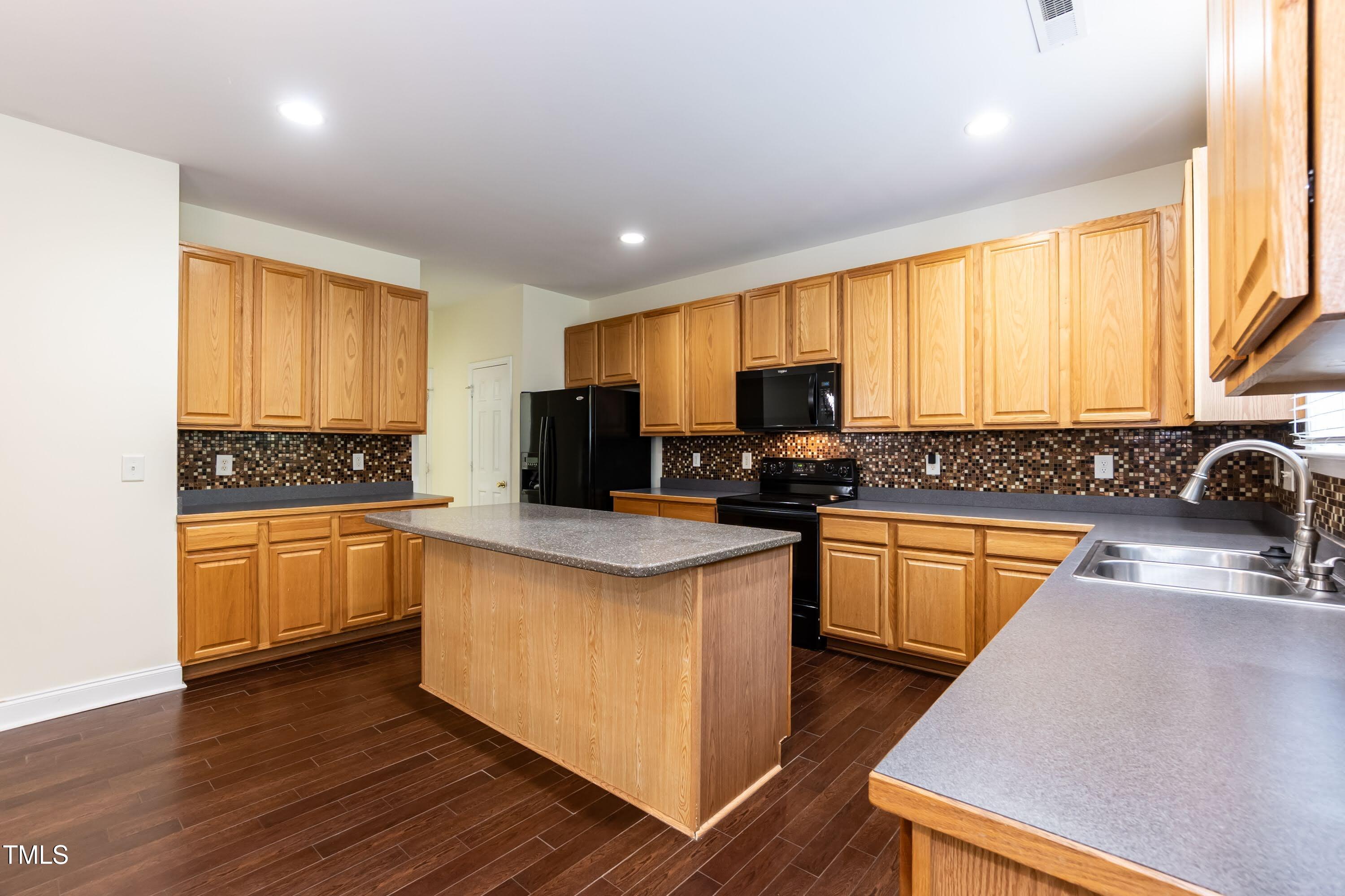 418 Byrams Ford Drive Cary, NC 27513 - Photo 15 of 53 a kitchen with granite countertop a stove top oven a sink dishwasher a dining table and chairs with wooden floor
