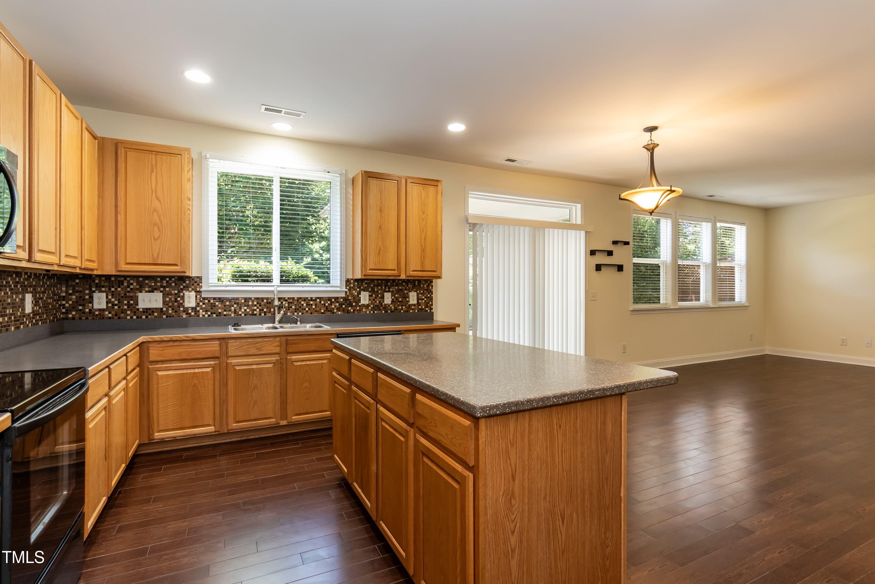 418 Byrams Ford Drive Cary, NC 27513 - Photo 18 of 53 a kitchen with stainless steel appliances granite countertop a sink a stove and a wooden floors