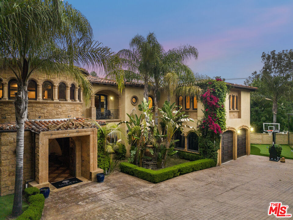 18607 Cassandra Street Tarzana, CA 91356 - Photo 2 of 58 a front view of a house with a yard and potted plants