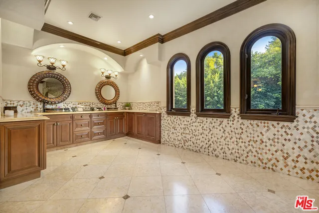 a bathroom with a granite countertop sink a mirror a bathtub and shower
