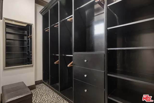 a spacious bedroom with a bed and a chandelier