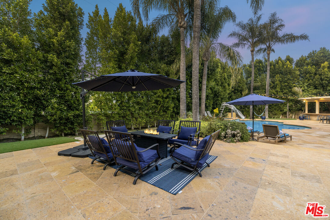 18607 Cassandra Street Tarzana, CA 91356 - Photo 51 of 58 a view of a backyard with a patio table and chairs
