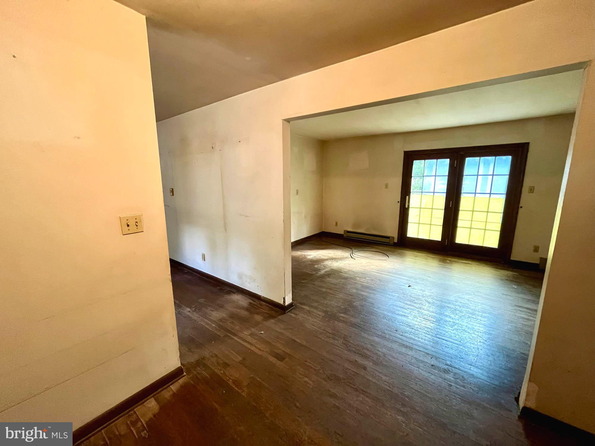 4992 Millers Station Road Hampstead, MD 21074 - Photo 6 of 24 an empty room with wooden floor and windows