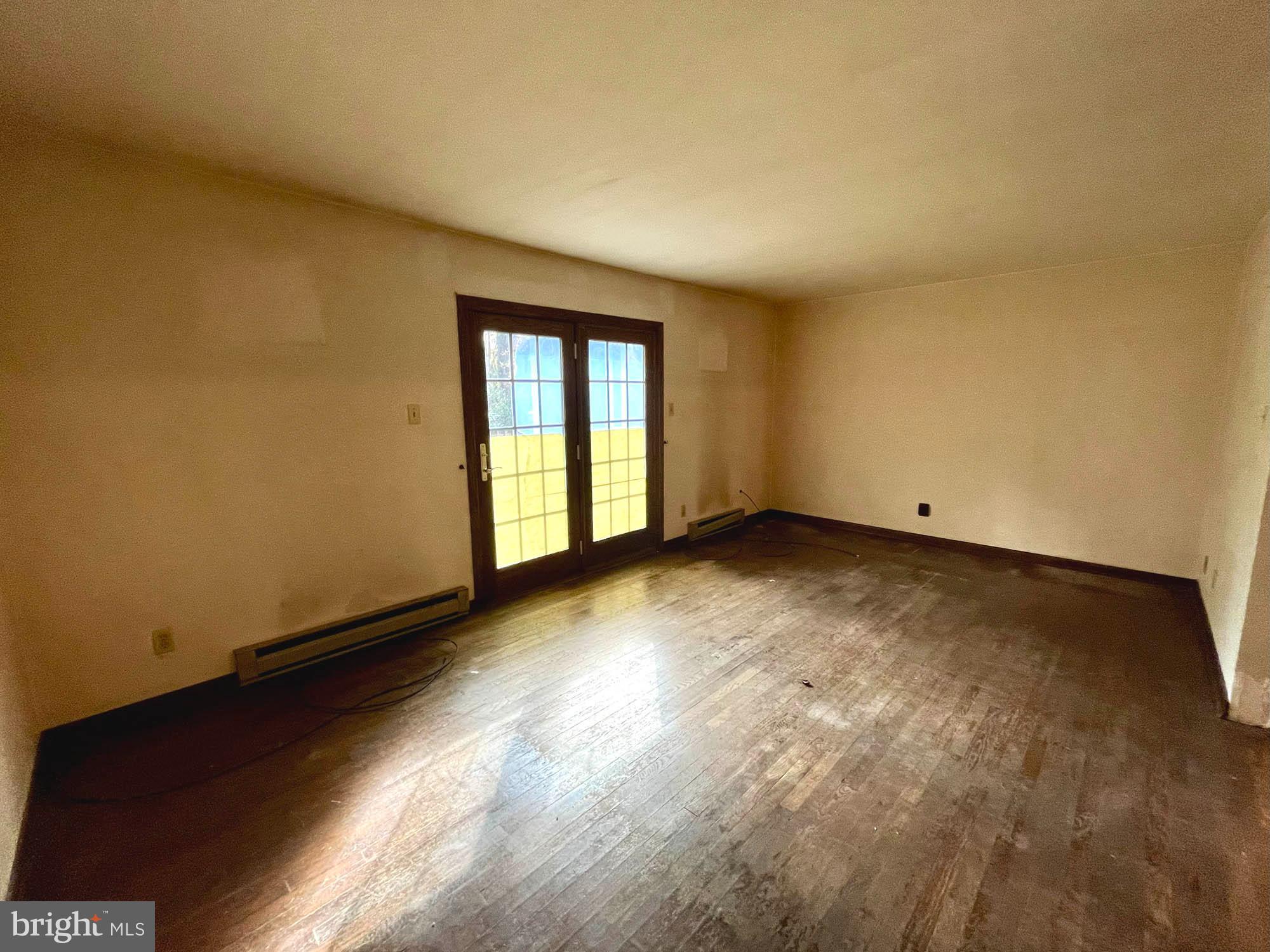 4992 Millers Station Road Hampstead, MD 21074 - Photo 7 of 24 an empty room with wooden floor and windows