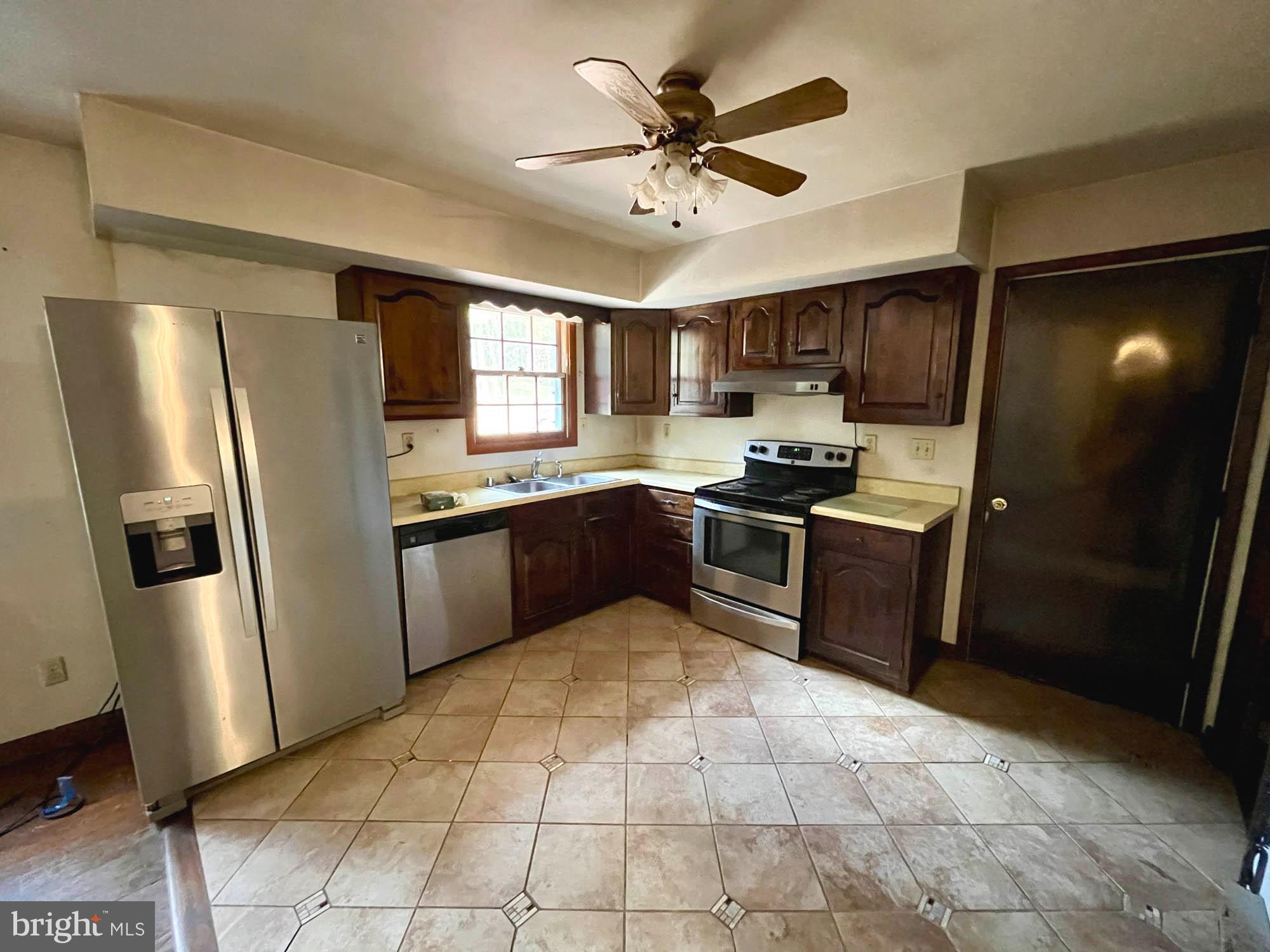 4992 Millers Station Road Hampstead, MD 21074 - Photo 9 of 24 a kitchen with stainless steel appliances granite countertop a refrigerator a sink a stove a microwave a counter top cabinets and a window