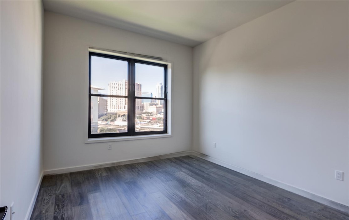 800 Embassy Drive, Unit 233 Austin, TX 78702 - Photo 15 of 40 an empty room with wooden floor and windows