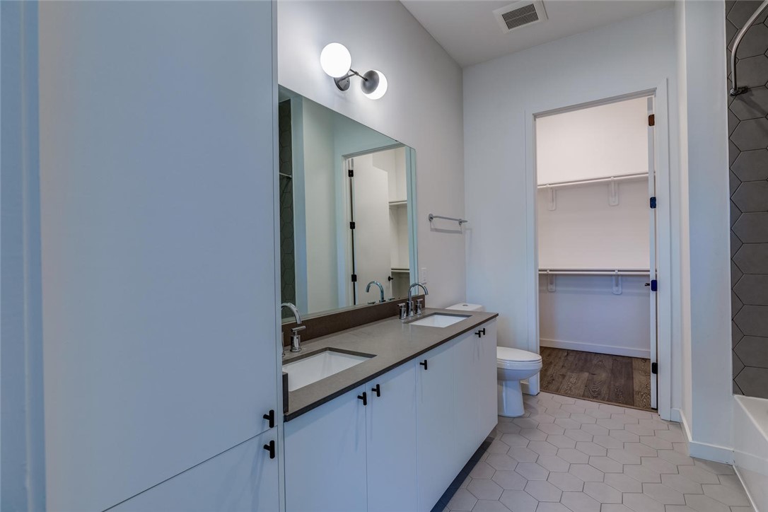 800 Embassy Drive, Unit 233 Austin, TX 78702 - Photo 19 of 40 a bathroom with a granite countertop sink and a mirror