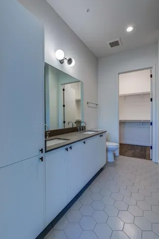 a bathroom with a granite countertop sink a mirror a bathtub and shower