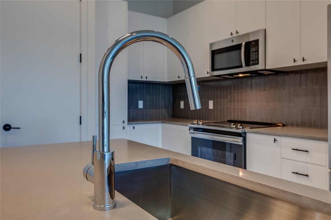 800 Embassy Drive, Unit 233 Austin, TX 78702 - Photo 28 of 40 a kitchen with granite countertop a stove and a microwave