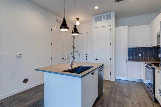 a kitchen with stainless steel appliances granite countertop a stove and a microwave