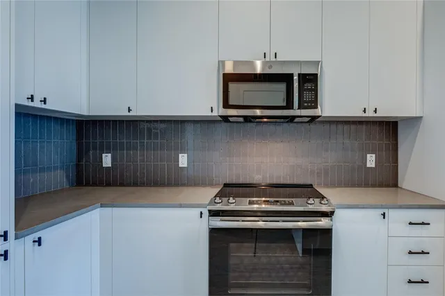 a kitchen with stainless steel appliances a refrigerator and a stove top oven