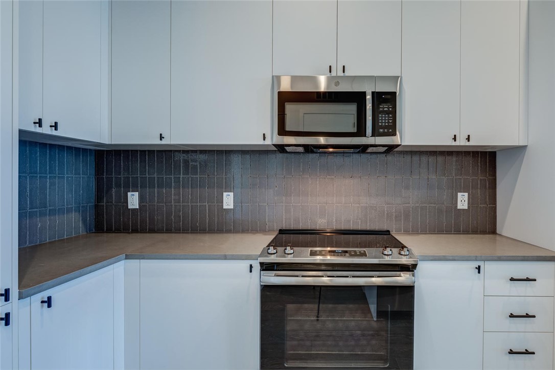 800 Embassy Drive, Unit 233 Austin, TX 78702 - Photo 10 of 40 a kitchen with stainless steel appliances granite countertop a stove and a microwave