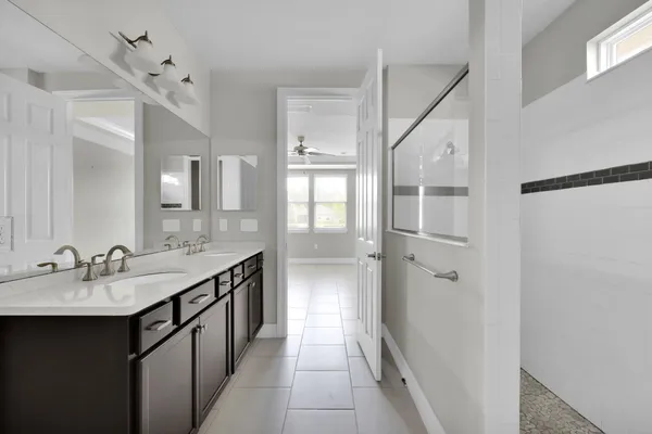 a view of an empty room with window and a kitchen view