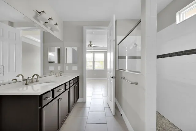 a view of an empty room with window and a kitchen view
