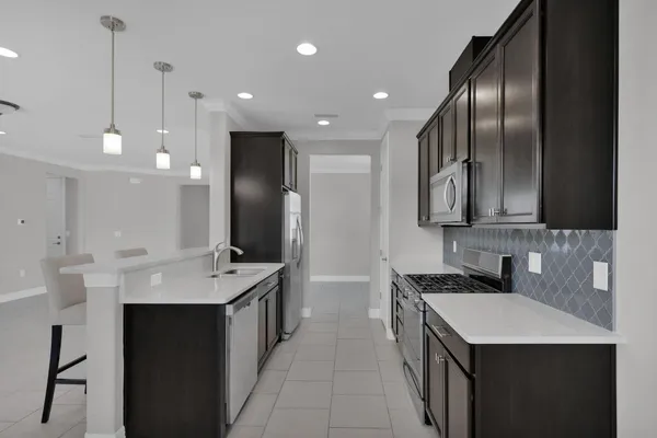 a kitchen with stainless steel appliances a stove a microwave and white cabinets