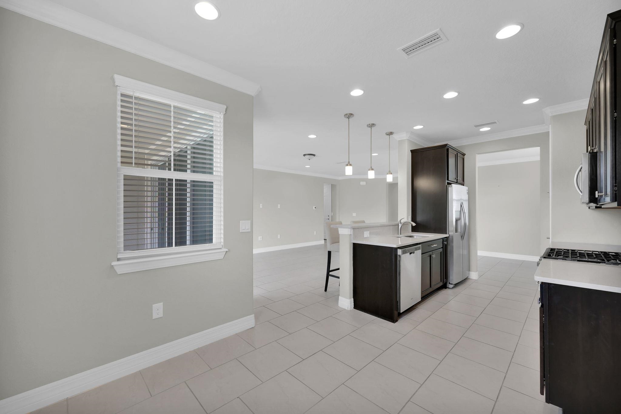 164 Front Door Lane St. Augustine, FL 32095 - Photo 20 of 42 a large kitchen with stainless steel appliances kitchen island granite countertop a refrigerator and a stove top oven