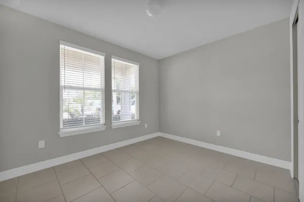 an empty room with windows and fan