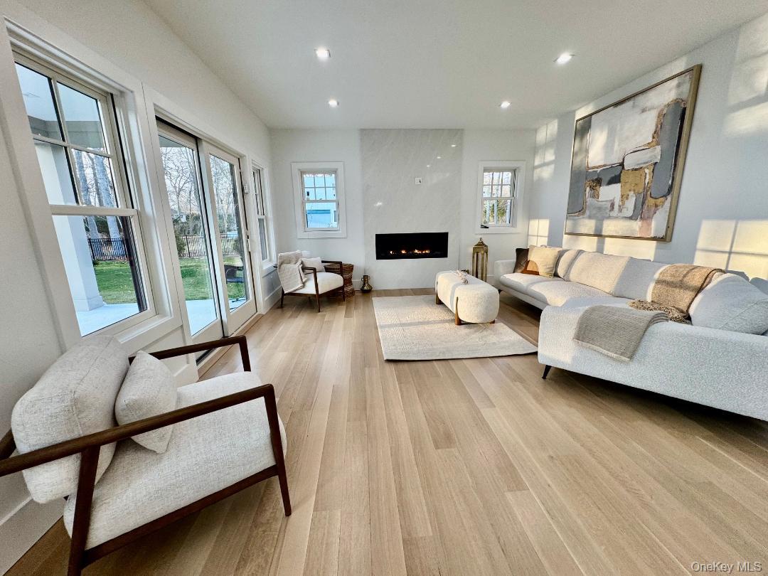 69 Jagger Lane Westhampton, NY 11977 - Photo 21 of 50 Warm & inviting open living room with gas fireplace, double door walk out to marble patio, rear yard.