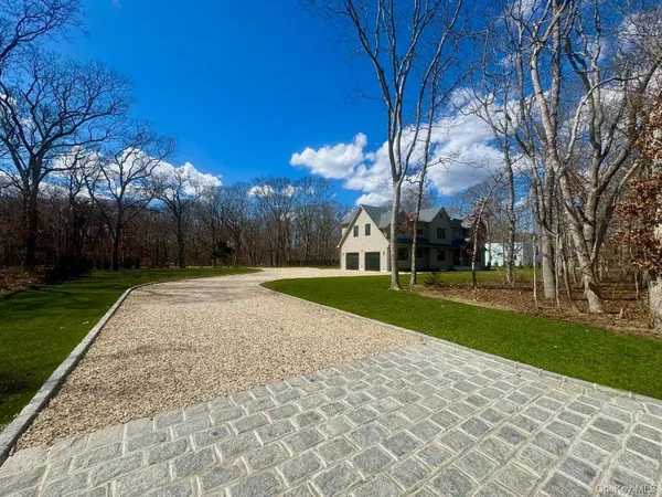 a view of a kitchen with kitchen island a large counter top space a sink stainless steel appliances and cabinets