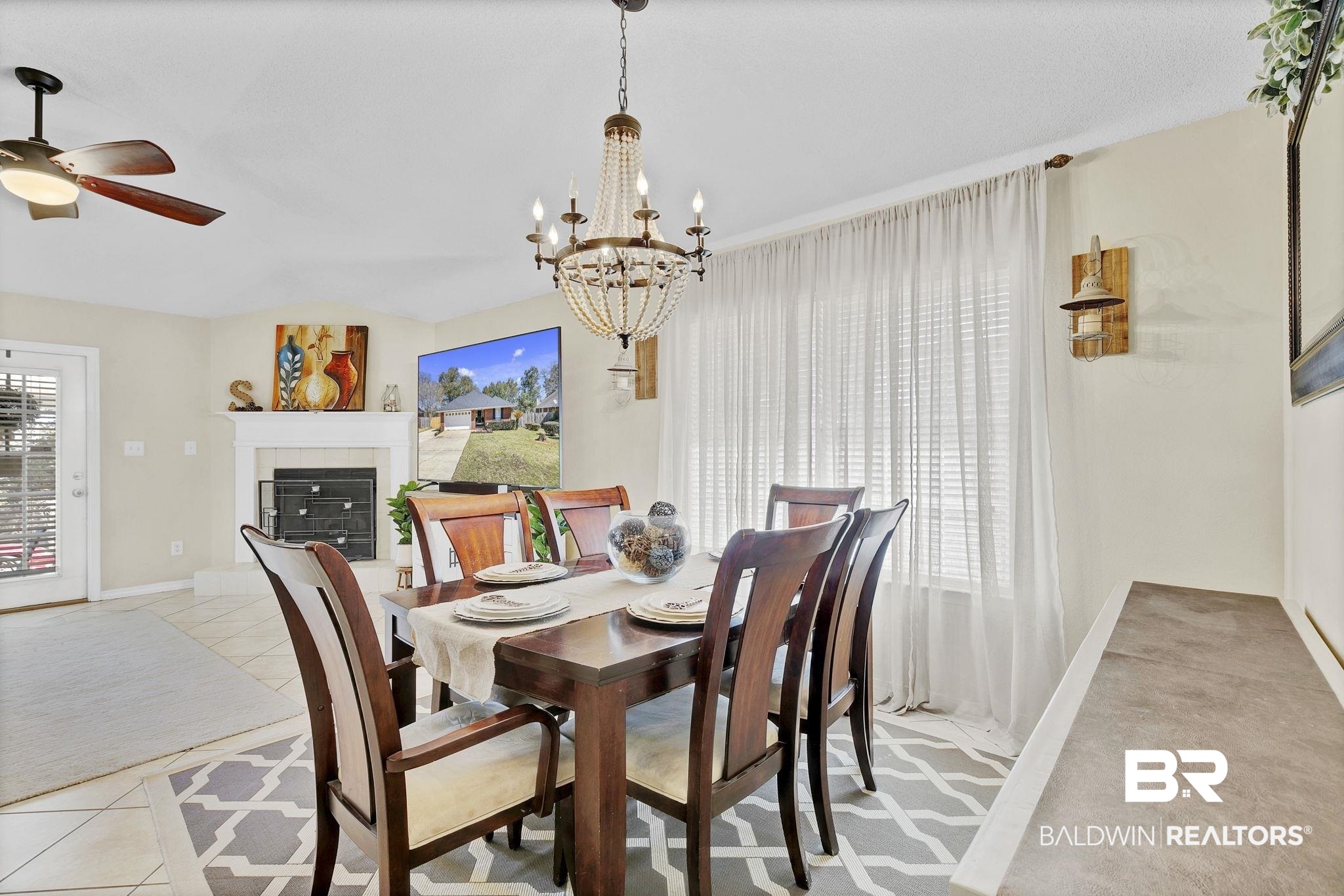 11103 Pontchartrain Loop Daphne, AL 36526 - Photo 15 of 29 Dining room with ceiling fan with notable chandelier, a fireplace, light tile patterned floors, baseboards, and light colored carpet
