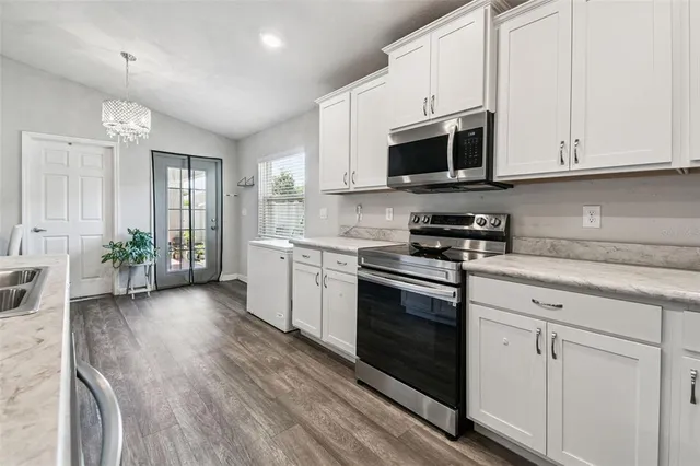 a kitchen with kitchen island granite countertop a sink a center island and appliances