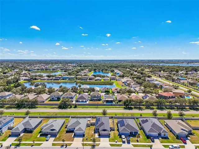 a view of a sign board with flower plants in front of it