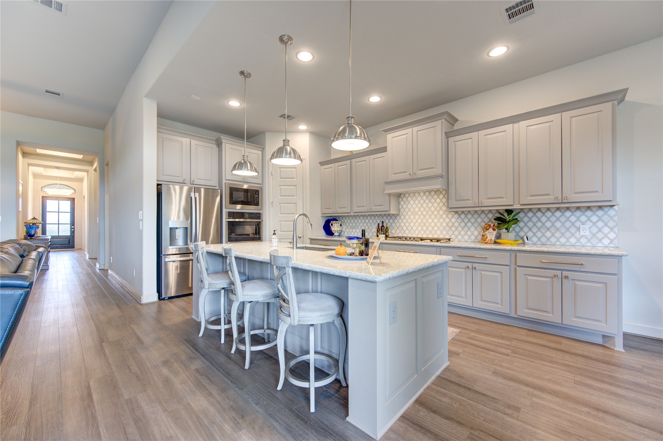 7326 Orangetip Road Katy, TX 77493 - Photo 12 of 43 This chef-inspired kitchen is designed for both beauty and functionality, featuring sleek Quartz countertops, custom cabinetry, and a spacious island with bar seating—perfect for casual dining or entertaining guests. High-end stainless steel appliances, including a gas cooktop and built-in oven, ensure a seamless cooking experience.
