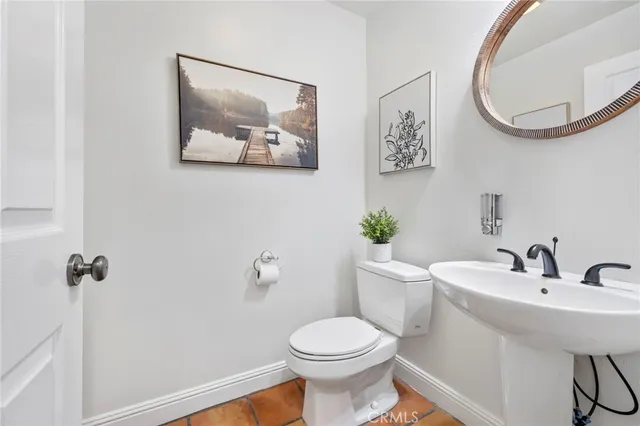a bathroom with a toilet a sink and mirror