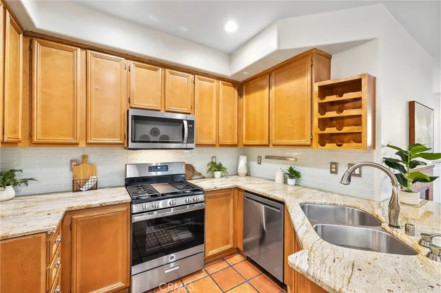 a kitchen with stainless steel appliances a sink a stove and a microwave
