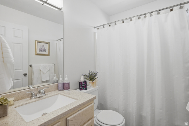 7737 Ranches Parkway Eagle Mountain, UT 84005 - Photo 15 of 28 Bathroom featuring a light-toned vanity with an integrated sink, a speckled countertop, and a vanity-width mirror